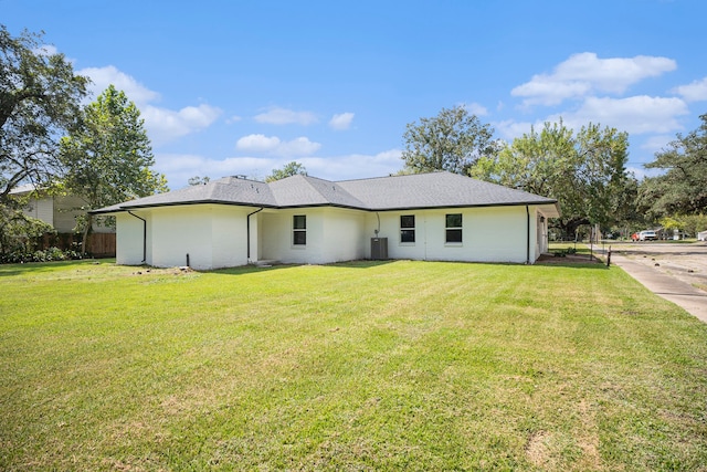 ranch-style home featuring cooling unit and a front yard