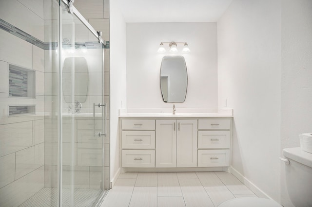 bathroom featuring vanity, toilet, and a shower with shower door