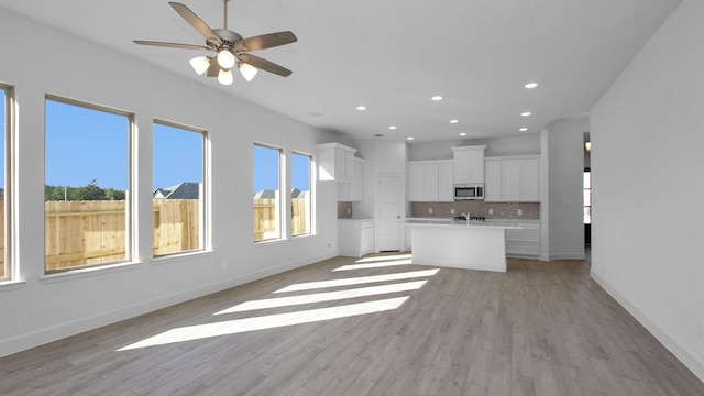 unfurnished living room featuring light hardwood / wood-style floors and ceiling fan