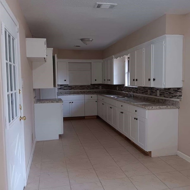 kitchen featuring white cabinetry, sink, and backsplash