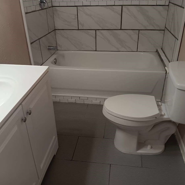 full bathroom featuring vanity, tiled shower / bath combo, toilet, and tile patterned floors