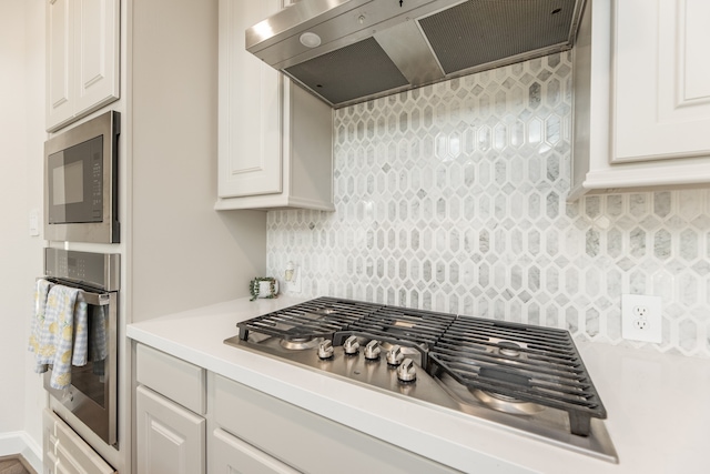 kitchen with white cabinetry, stainless steel appliances, and extractor fan