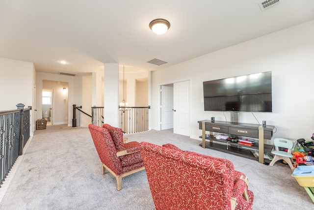 carpeted living room with a notable chandelier