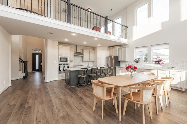 dining room featuring a high ceiling and hardwood / wood-style floors