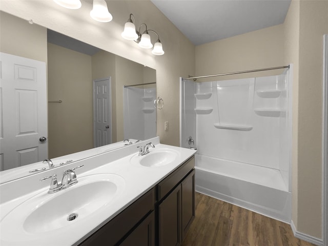 bathroom featuring wood-type flooring, washtub / shower combination, and vanity