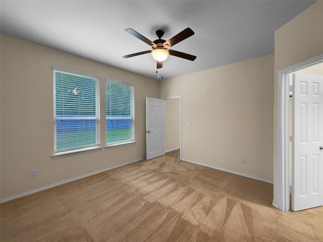 carpeted spare room with ceiling fan