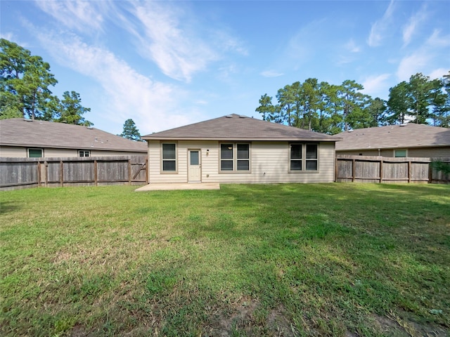 back of house with a lawn and a patio