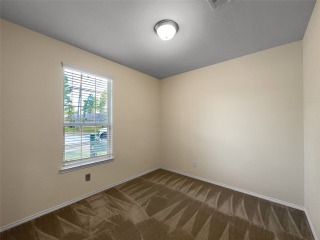 unfurnished room with dark carpet