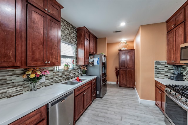 kitchen featuring light wood-type flooring, appliances with stainless steel finishes, backsplash, and sink