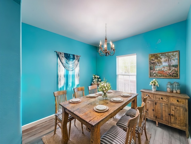 dining space featuring a notable chandelier and light wood-type flooring