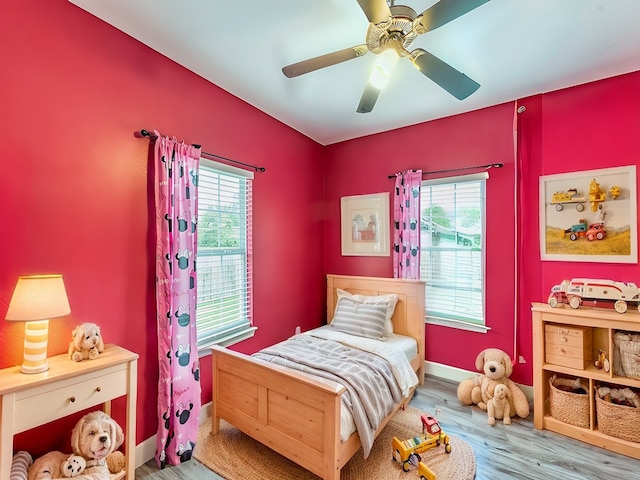 bedroom with light hardwood / wood-style floors, multiple windows, and ceiling fan