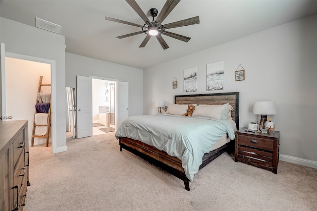 bedroom featuring a spacious closet, a closet, ceiling fan, ensuite bathroom, and light carpet