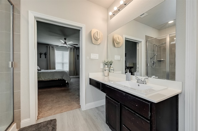 bathroom with ceiling fan, vanity, hardwood / wood-style floors, and an enclosed shower