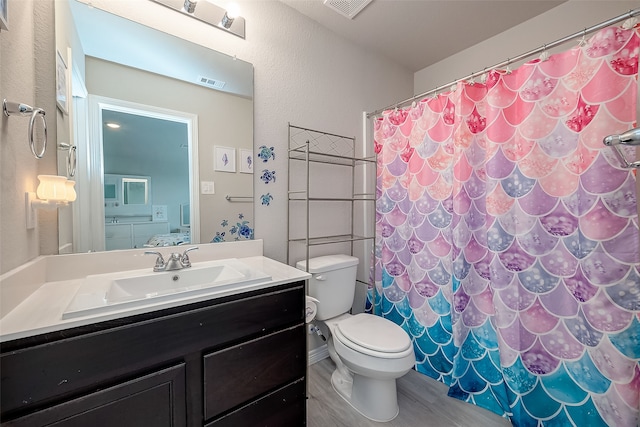 bathroom featuring wood-type flooring, vanity, walk in shower, and toilet