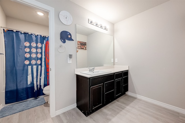 bathroom featuring wood-type flooring, vanity, and toilet