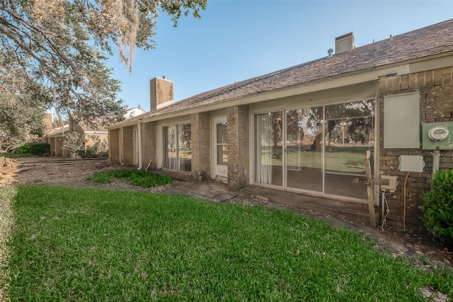 rear view of property featuring a yard