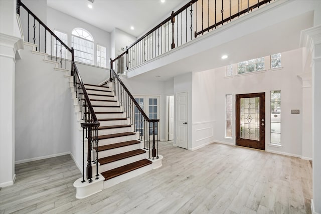 entryway featuring a towering ceiling and light hardwood / wood-style floors