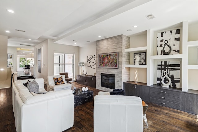 living room featuring a fireplace, dark wood-type flooring, and built in features