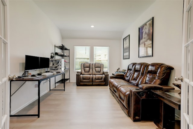 living room with light hardwood / wood-style flooring and vaulted ceiling