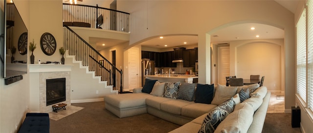 carpeted living room featuring a high ceiling and sink