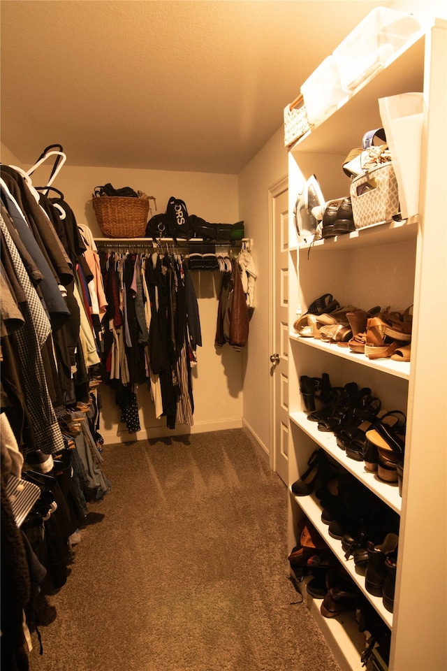 walk in closet featuring dark colored carpet