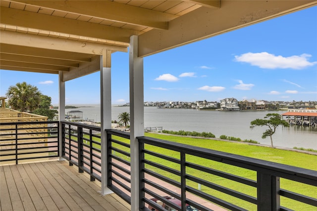 wooden deck featuring a lawn and a water view