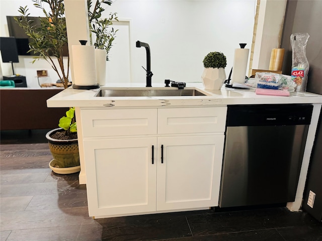 kitchen with stainless steel dishwasher, dark hardwood / wood-style floors, white cabinets, and sink