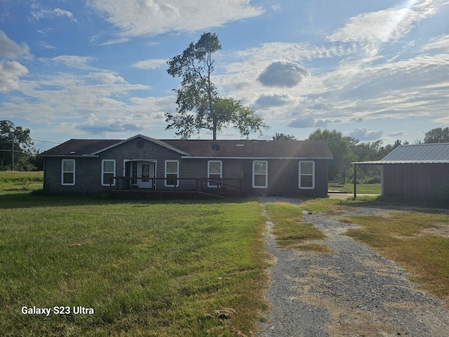 ranch-style home featuring driveway, a front yard, and a wooden deck