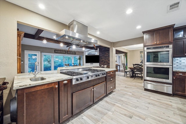 kitchen featuring a warming drawer, island exhaust hood, stainless steel appliances, visible vents, and glass insert cabinets