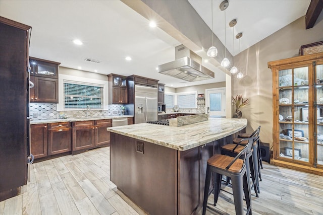 kitchen with decorative backsplash, a spacious island, appliances with stainless steel finishes, glass insert cabinets, and pendant lighting