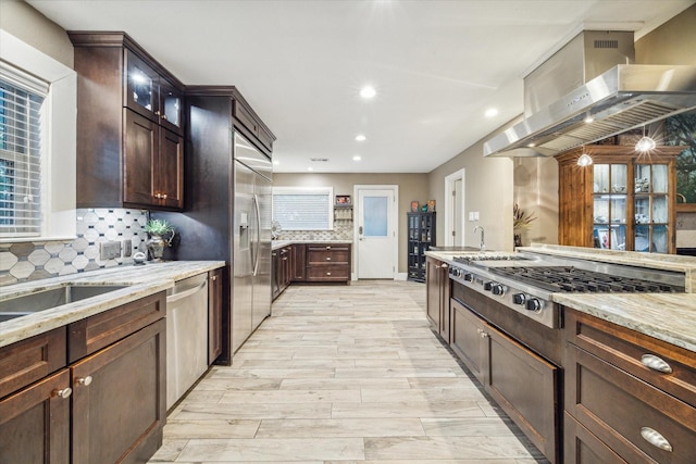 kitchen with stainless steel appliances, glass insert cabinets, island range hood, and dark brown cabinets