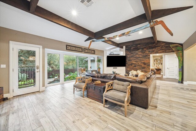 living room featuring lofted ceiling with beams and light wood-type flooring