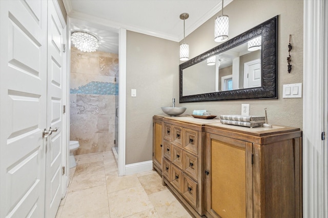 bathroom with double vanity, a stall shower, toilet, crown molding, and a sink