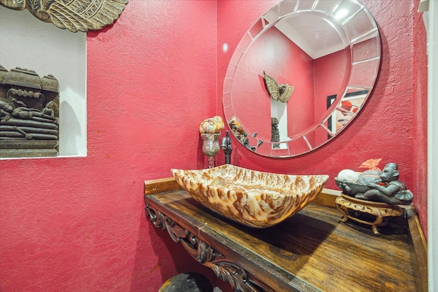 interior space featuring a textured wall and vanity