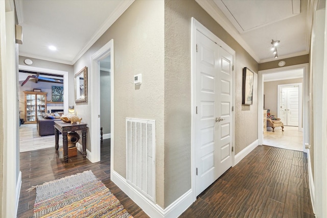 hallway featuring dark wood-style floors, attic access, visible vents, and crown molding