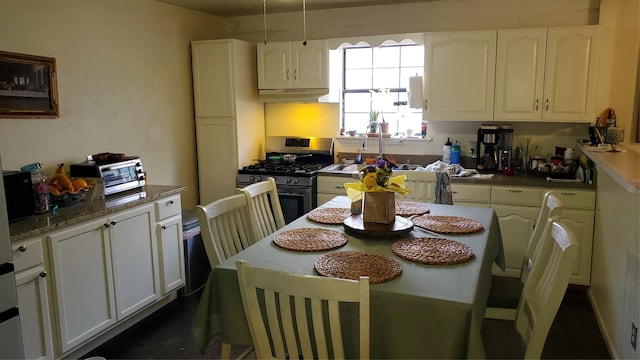 kitchen featuring sink, stainless steel range with gas cooktop, and white cabinetry