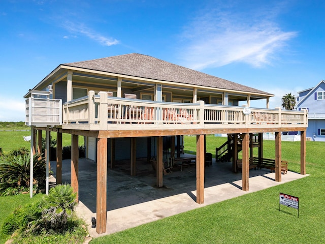 back of property with a yard, a carport, and a deck