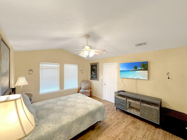 bedroom featuring ceiling fan, light hardwood / wood-style flooring, and lofted ceiling