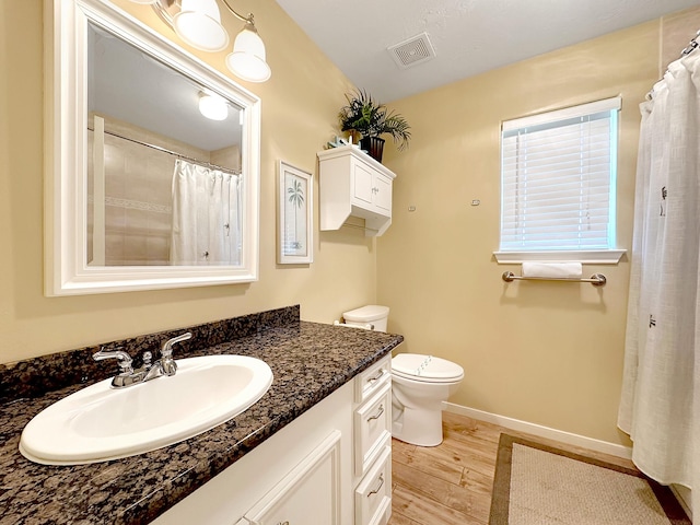 bathroom with wood-type flooring, vanity, and toilet