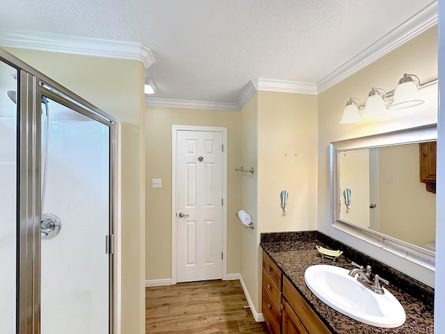 bathroom featuring vanity, crown molding, hardwood / wood-style floors, and a textured ceiling