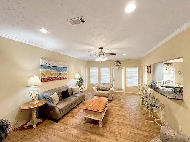 living room with light hardwood / wood-style flooring, ceiling fan, and ornamental molding