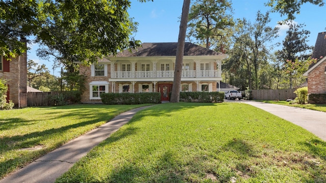 view of front facade with a balcony and a front yard