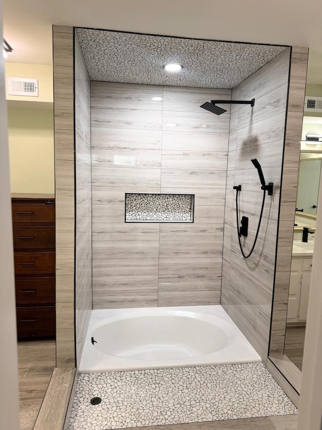 bathroom featuring vanity and tiled shower / bath combo