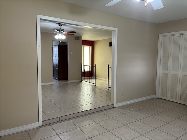 tiled empty room with ceiling fan