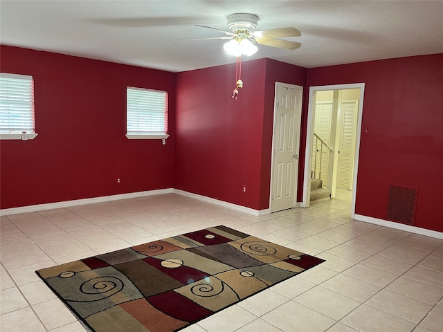 tiled spare room with ceiling fan