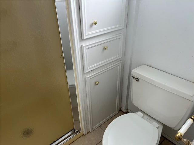 bathroom with a shower, tile patterned floors, and toilet