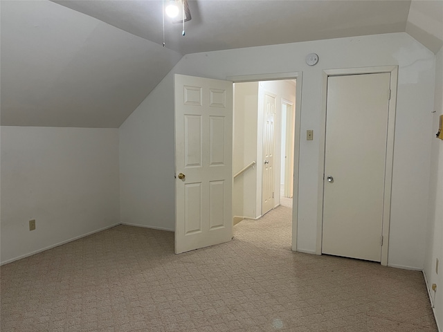 additional living space featuring vaulted ceiling, ceiling fan, and light colored carpet