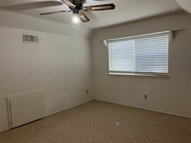 empty room with lofted ceiling, light carpet, and ceiling fan