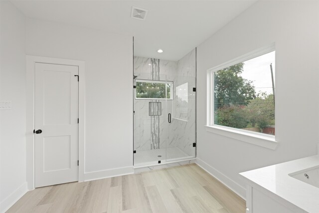 bathroom featuring vanity, a shower with shower door, and hardwood / wood-style floors