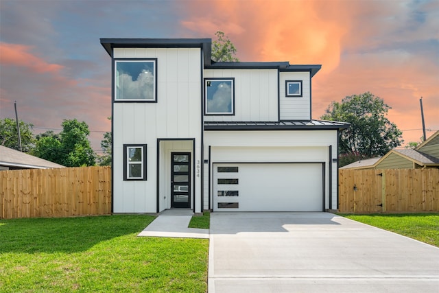 contemporary home with a garage and a lawn